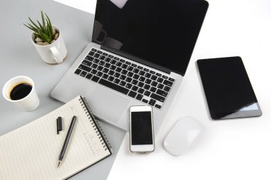 Dizüstü bilgisayar, dizüstü bilgisayar, dijital tablet ve modern iki ton (beyaz ve gri) arka plan üstünde smartphone ile ofis masaları.