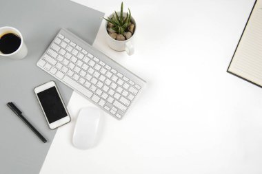 Klavye, fare, defter ve smartphone modern iki ton (beyaz ve gri) arka plan üzerinde ofis masaları.