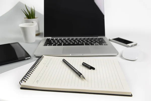 Tabel kantor dengan komputer laptop, notebook, tablet digital dan smartphone pada latar belakang modern dua nada (putih dan abu-abu) . — Stok Foto