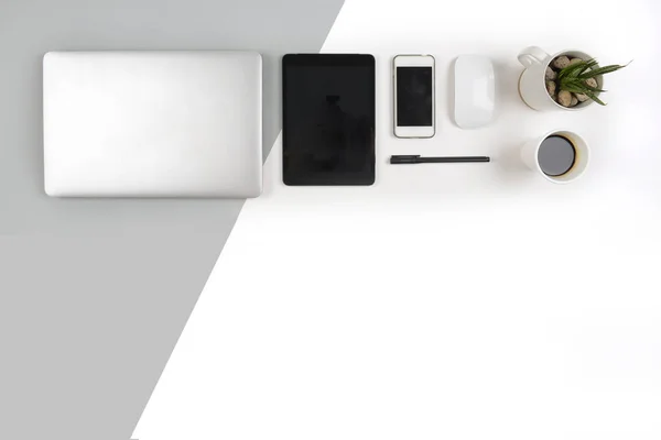 Mesa de oficina con ordenador portátil, portátil, tableta digital y smartphone en un moderno fondo bicolor (blanco y gris) . —  Fotos de Stock