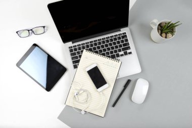 Dizüstü bilgisayar, dizüstü bilgisayar, dijital tablet ve modern iki ton (beyaz ve gri) arka plan üstünde hareket eden telefon ile ofis masaları.