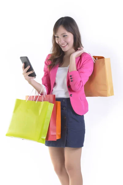 Compras jovens mulheres asiáticas segurando telefone celular e sacos de compras no fundo do estúdio branco. (Venda e compras online conceito ) — Fotografia de Stock