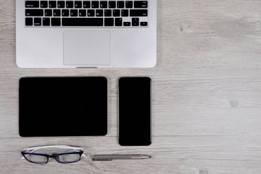 Ofis Masaları dizüstü bilgisayar, dijital tablet, kalem, smartphone ve gözlük beyaz tahta arka plan ile. Masaüstü ofis mockup kavramı.