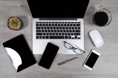Ofis Masaları dizüstü bilgisayar, dijital tablet, kalem, smartphone, fare, gözlük ve kahve beyaz tahta arka plan ile. Masaüstü ofis mockup kavramı.