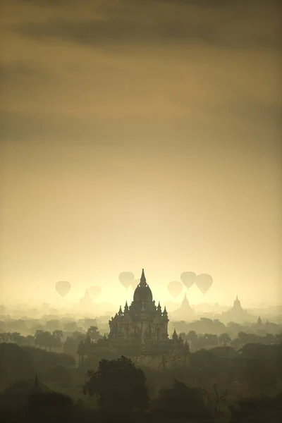 Sunrise scénu horkovzdušné balóny létat nad pole starověké město pagoda Bagan, Myanmar. (Vysoká obrazová kvalita) — Stock fotografie