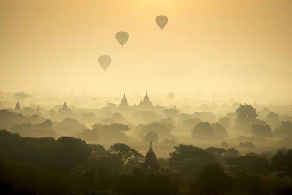 Sunrise scénu horkovzdušné balóny létat nad pole starověké město pagoda Bagan, Myanmar. (Vysoká obrazová kvalita) — Stock fotografie