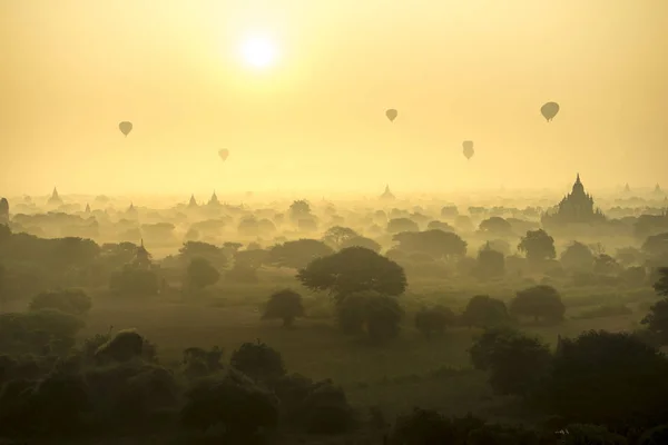 Sunrise scénu horkovzdušné balóny létat nad pole starověké město pagoda Bagan, Myanmar. (Vysoká obrazová kvalita) — Stock fotografie