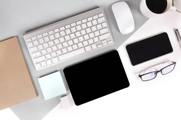 Foto plana de mesa de oficina con teclado, notebook, tableta digital, teléfono móvil, lápiz, anteojos sobre fondo moderno de dos tonos (blanco y gris). Escritorio concepto de maqueta de oficina . — Foto de Stock