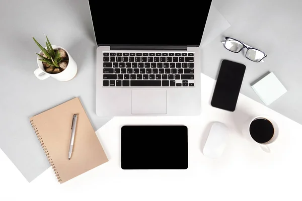 Flat lay foto de la mesa de Office con ordenador portátil, portátil, tableta digital, teléfono móvil, lápiz, gafas sobre fondo moderno de dos tonos (blanco y gris). Escritorio concepto de maqueta de oficina . —  Fotos de Stock