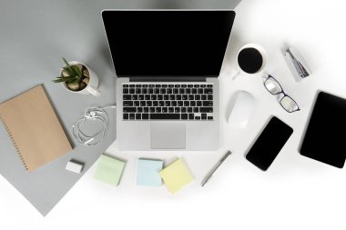 Ofis Masaları dizüstü bilgisayar, cep telefonu, kalem, defter, dijital tablet ile düz yatıyordu fotoğrafı modern iki ton (beyaz ve gri) arka plan gözlük. Masaüstü ofis mockup kavramı.