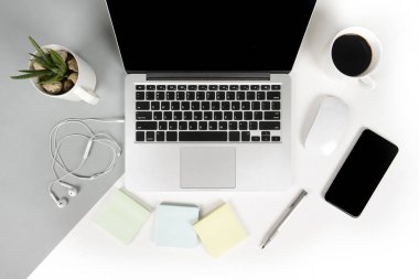 Ofis Masaları dizüstü bilgisayar, cep telefonu, kalem, defter, dijital tablet ile düz yatıyordu fotoğrafı modern iki ton (beyaz ve gri) arka plan gözlük. Masaüstü ofis mockup kavramı.