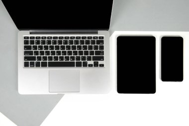 Ofis Masaları dizüstü bilgisayar, dizüstü bilgisayar, dijital tablet ve modern iki ton (beyaz ve gri) arka plan üstünde hareket eden telefon ile düz yatıyordu fotoğraf. Masaüstü ofis mockup kavramı.