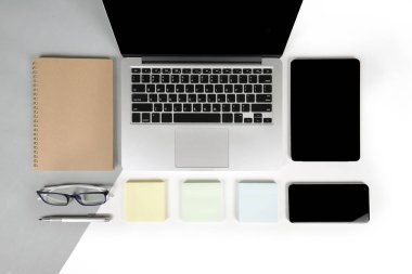Ofis Masaları dizüstü bilgisayar, cep telefonu, kalem, defter, dijital tablet ile düz yatıyordu fotoğrafı modern iki ton (beyaz ve gri) arka plan gözlük. Masaüstü ofis mockup kavramı.