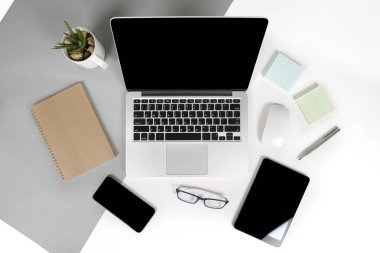 Ofis Masaları dizüstü bilgisayar, cep telefonu, kalem, defter, dijital tablet ile düz yatıyordu fotoğrafı modern iki ton (beyaz ve gri) arka plan gözlük. Masaüstü ofis mockup kavramı.