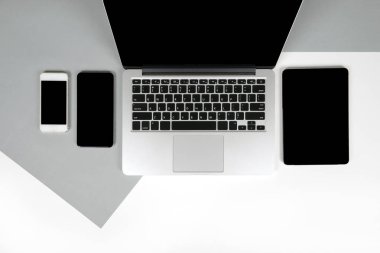 Ofis Masaları dizüstü bilgisayar, dizüstü bilgisayar, dijital tablet ve modern iki ton (beyaz ve gri) arka plan üstünde hareket eden telefon ile düz yatıyordu fotoğraf. Masaüstü ofis mockup kavramı.