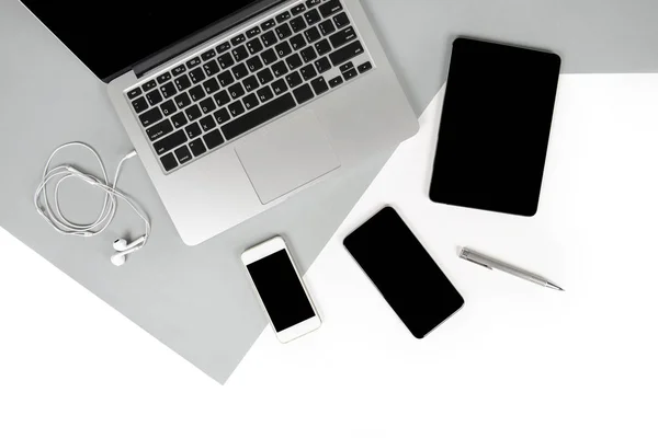Flat lay foto de la mesa de Office con ordenador portátil, portátil, tableta digital, teléfono móvil, lápiz sobre fondo moderno de dos tonos (blanco y gris). Escritorio concepto de maqueta de oficina . — Foto de Stock