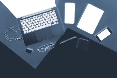 Ofis Masaları dizüstü bilgisayar, cep telefonu, dizüstü bilgisayar, dijital tablet ile düz yatıyordu x-ışını fotoğrafı kalem modern iki ton (beyaz ve gri) arka plan üzerinde. Masaüstü ofis mockup kavramı.
