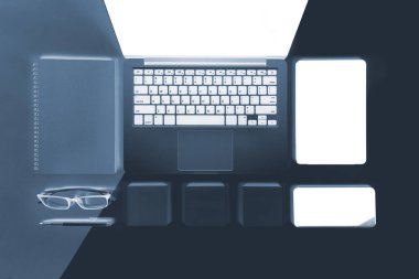 Ofis Masaları dizüstü bilgisayar, cep telefonu, kalem, defter, dijital tablet ile düz yatıyordu x-ışını fotoğrafı modern iki ton (beyaz ve gri) arka plan gözlük. Masaüstü ofis mockup kavramı.