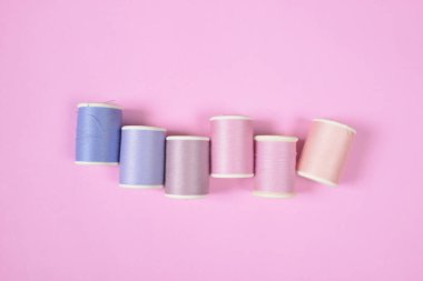 Düz lay renkli iplik dikiş için pembe arka plan alır., 