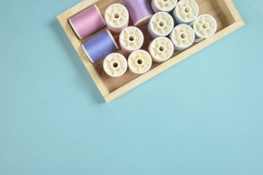 Düz lay renkli iplik dikiş için mavi arka plan üzerinde rulo., 