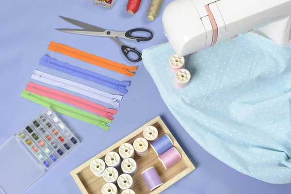 Tecidos na máquina de costura em meio à tesoura, botões de camisa, zipp — Fotografia de Stock
