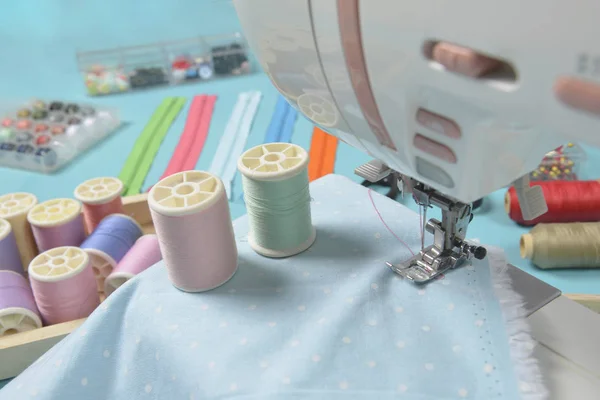 Fabrics on sewing machine amid the scissors, shirt buttons, zipp — Stock Photo, Image