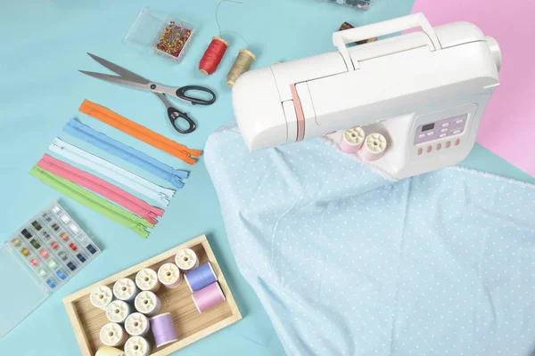 Tecidos na máquina de costura em meio à tesoura, botões de camisa, zipp — Fotografia de Stock