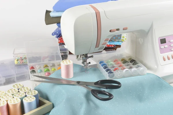 Maszyna do szycia i kolorowe wątku rolkach, nożyczki, tkaniny i — Zdjęcie stockowe