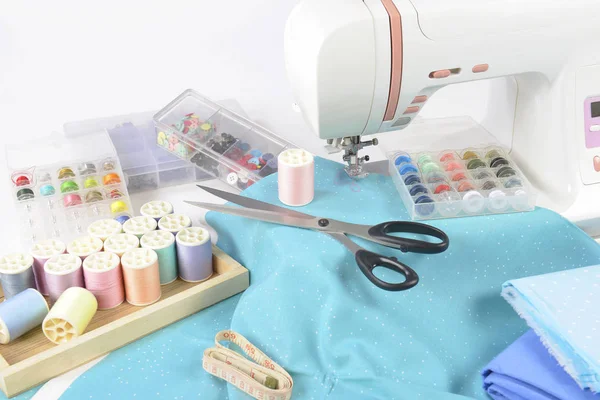 Machine à coudre et rouleaux de fil coloré, ciseaux, tissu et un — Photo
