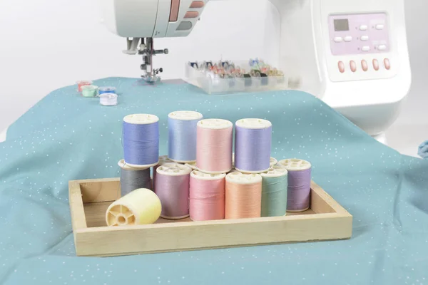 Sewing machine and colorful thread rolls, scissors, fabric and a — Stock Photo, Image