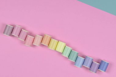 Düz lay renkli iplik dikiş için pembe arka plan alır., 