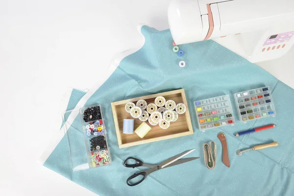 Máquina de coser y rollos de hilo de colores, tijeras, tela y una — Foto de Stock