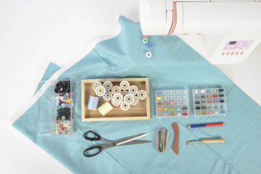 Dikiş makinesi ve renkli iplik rulo, makas, kumaş ve bir