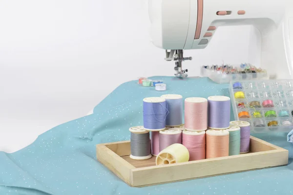 Sewing machine and colorful thread rolls, scissors, fabric and a — Stock Photo, Image