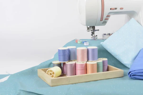 Sewing machine and colorful thread rolls, scissors, fabric and a — Stock Photo, Image