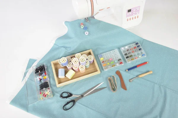 Máquina de costura e rolos de linha coloridos, tesoura, tecido e um — Fotografia de Stock