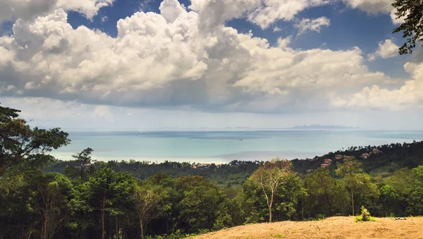 panoramik manzara yeşil orman Vadisi, tropik ada ile küçük bir köy. sakin deniz ve bulutlu gökyüzü. güneşli bir gün hedef doğal. hava deniz manzarası görünümü