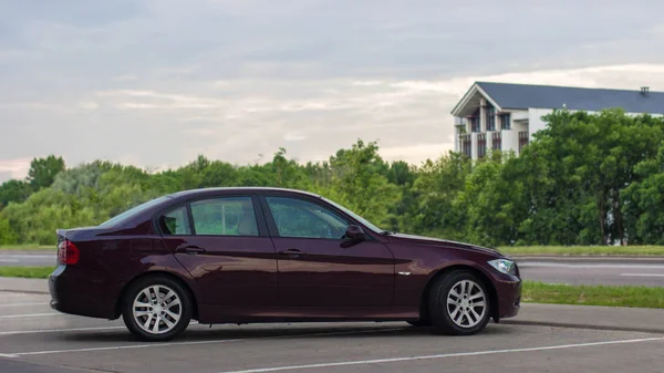 Kiraz kırmızı 4 kapı sedan bmw sokak Park üzerinde. Yan görünüm