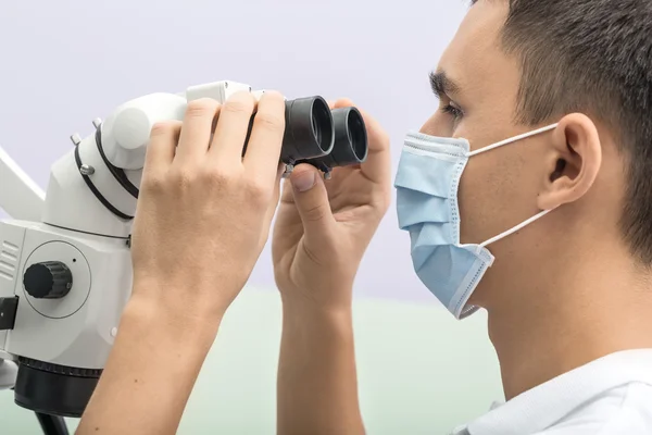 Dentista usando un microscopio dental — Foto de Stock