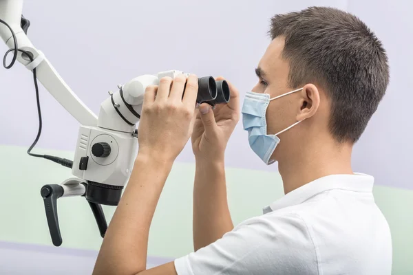 Dentista usando un microscopio dental — Foto de Stock