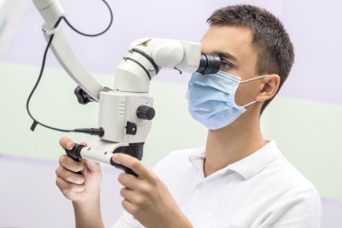 Doktor diş bir mikroskop kullanarak