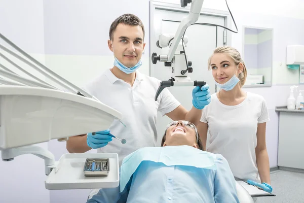 Dentist, assistant and patient in clinic — Stock Photo, Image