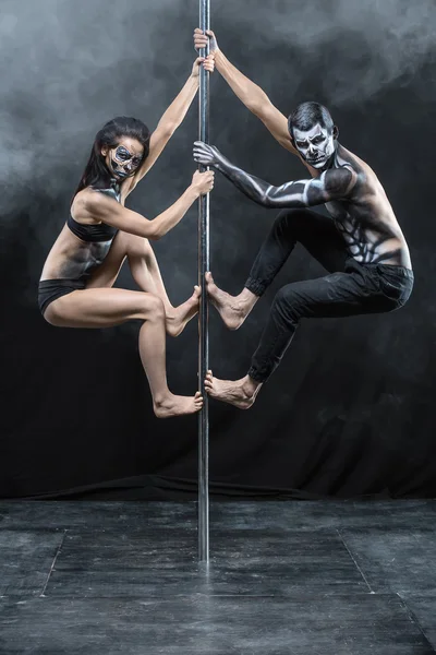 Pose de couple de pole dance en studio sombre — Photo
