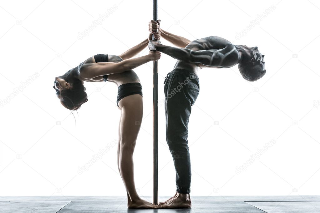 Posing of pole dance couple in studio