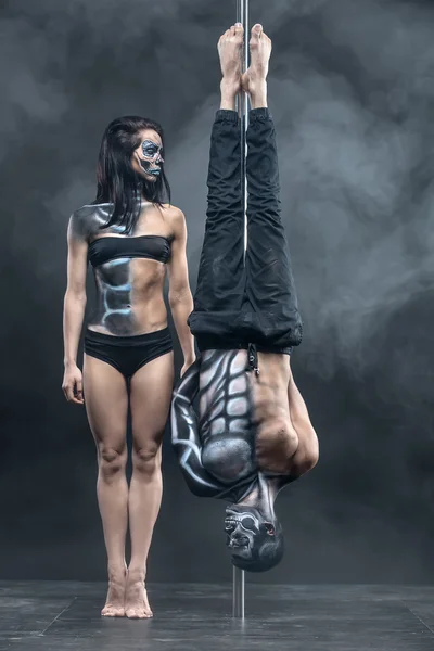 Posing of pole dance couple in dark studio — Stockfoto