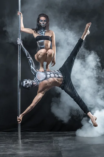 Posing of pole dance couple in dark studio — Stock fotografie