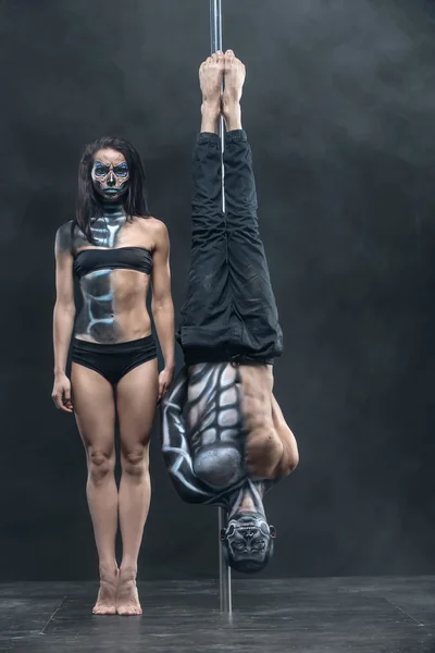 Posing of pole dance couple in dark studio — Stockfoto