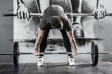 Spor salonunda halterle idman.