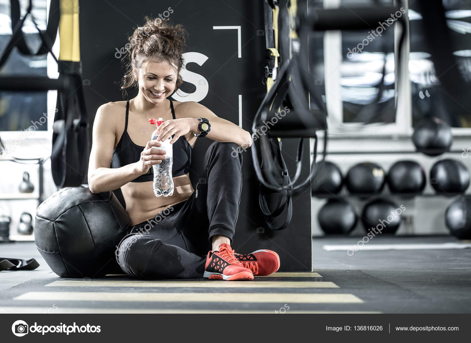 Физические упражнения. Бодибилдер тренировка. Тренировки между тренировками. Сколько нужно отдыхать между подходами. Девушка пьет воду в спортзале.
