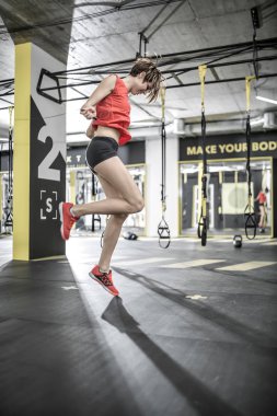 Sportif kız spor salonunda egzersiz yapıyor.